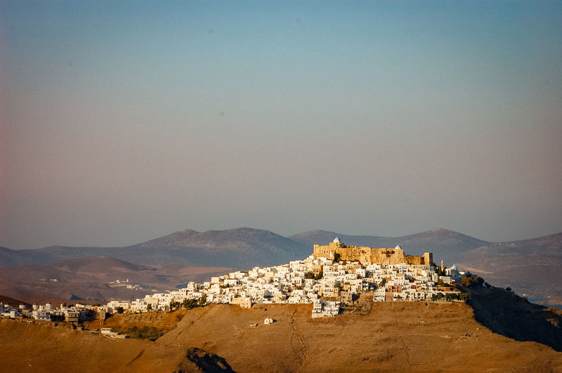 Panoramic view of townscape by mountains against clear sky