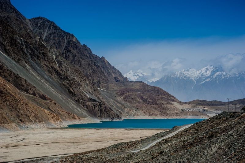Scenic view of lake and mountains against blue sky