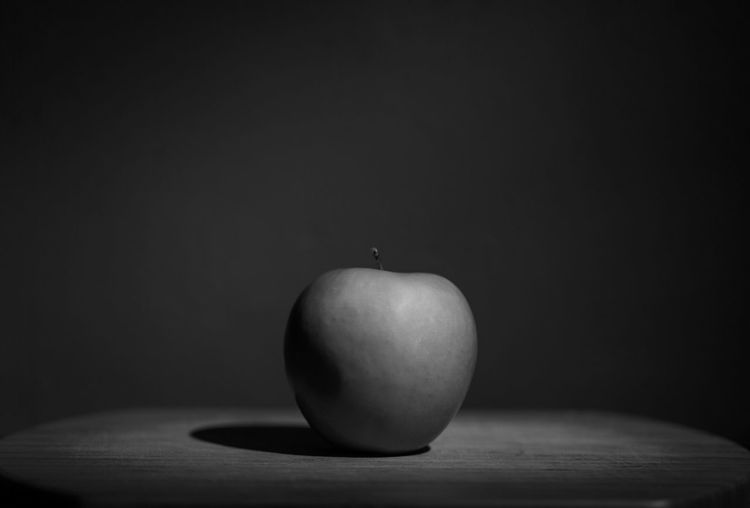Close-up of apple on table against black background