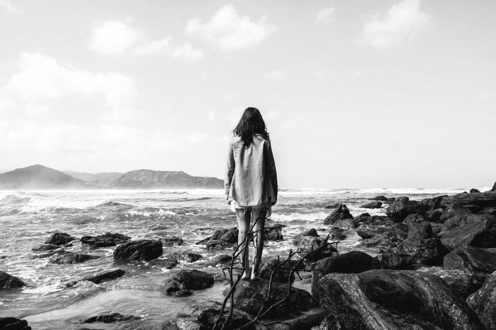 Woman standing on rocky beach