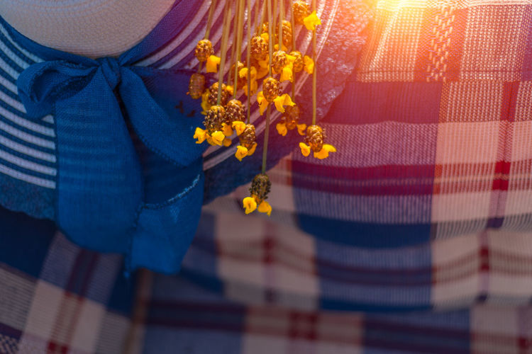 Close-up of hat with flowers on sofa