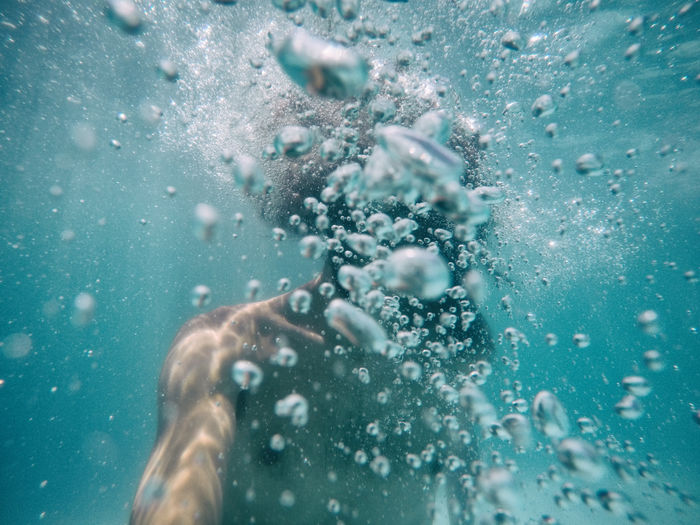 Close-up of shirtless man swimming underwater