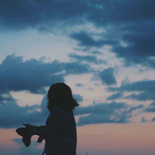 Silhouette woman standing against sky during sunset