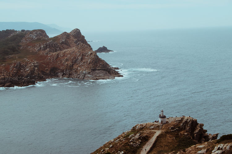 Rock formations by sea against sky