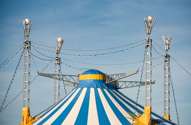 Low angle view of circus tent against blue sky