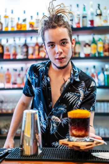 Portrait of young man drinking glasses