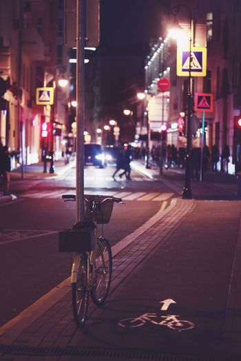 Bicycle parked on city street at night