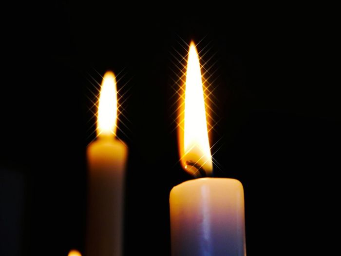 Close-up of burning candle in darkroom