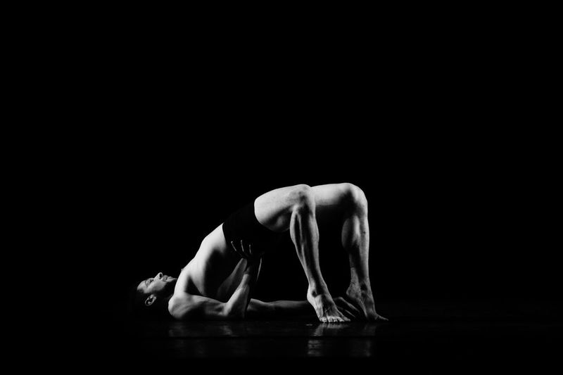 Midsection of person dancing against black background
