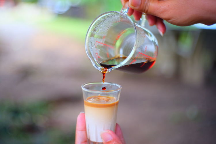 Close-up of person holding glass of juice