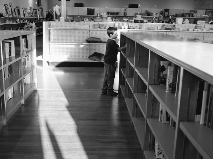 Boy standing by shelf in store
