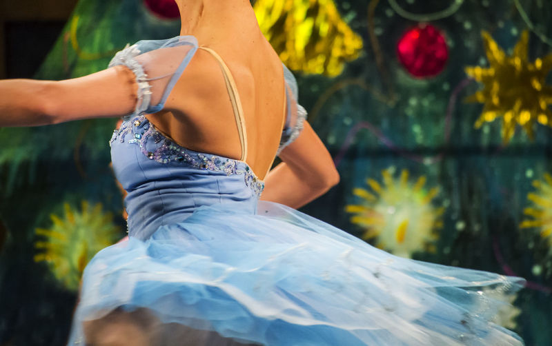 Midsection of ballerina dancing in blue dress