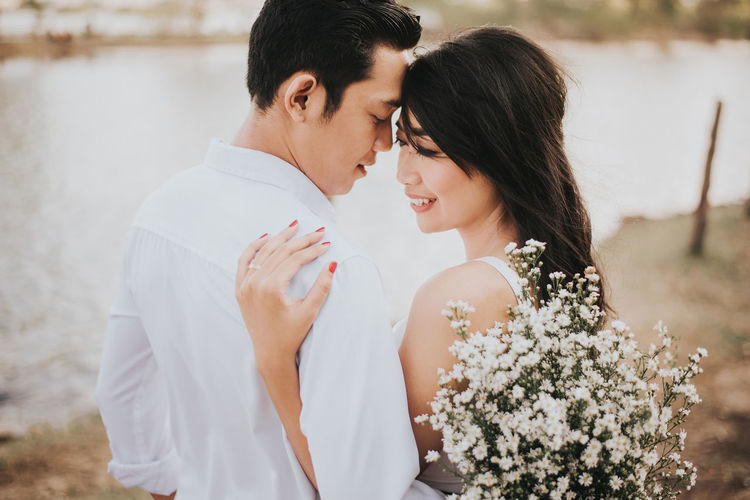 Young couple with white flowers romancing outdoors