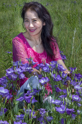 Portrait of smiling woman on purple flowering plants