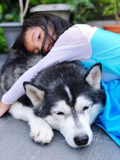 Portrait of girl with dog resting outdoors
