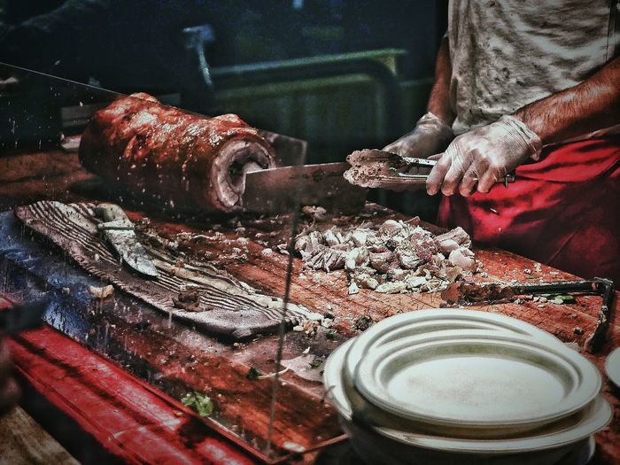 Midsection of man selling roast pork at queen victoria market