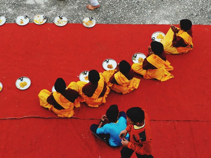 High angle view of people sitting on red carpet
