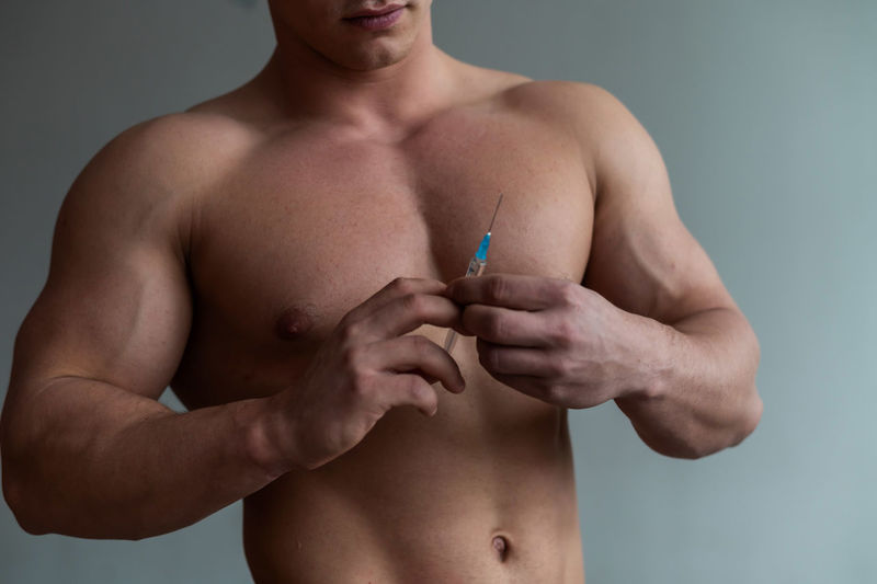 Midsection of shirtless man with hands