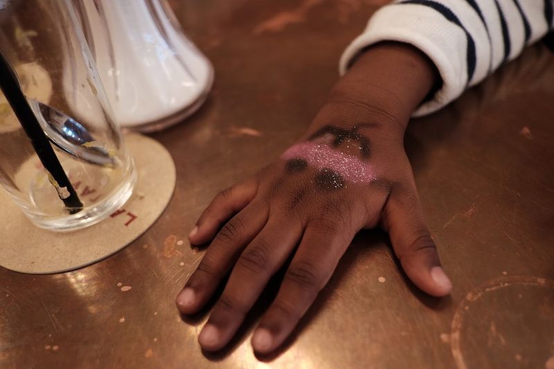 Cropped boy hand with tattoo on table