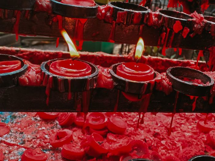 Close-up of red burning candles in temple