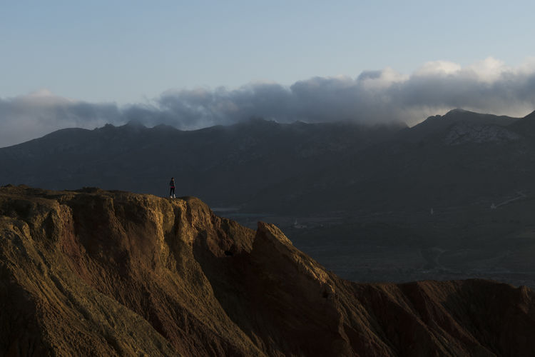 Woman on old abandoned mine view the mountains with clouds background in murcia, spain