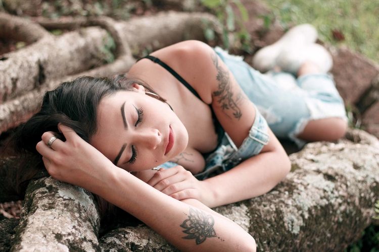 Young woman lying on roots