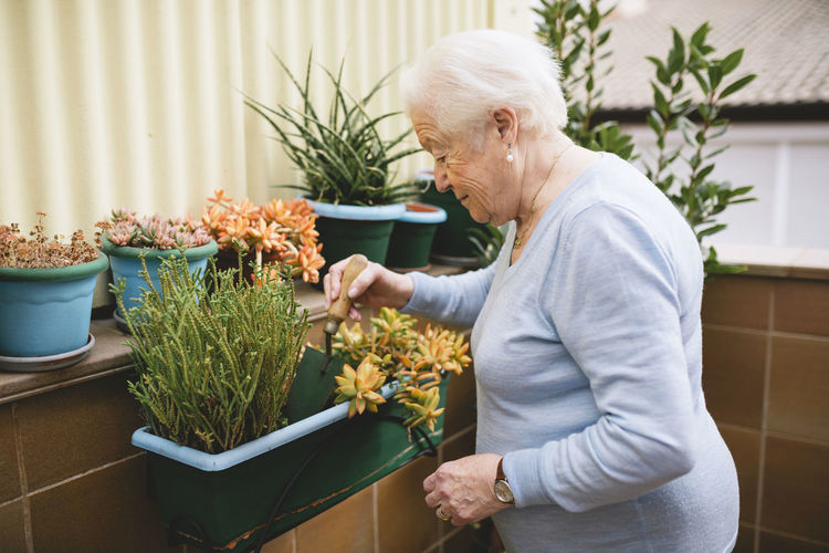 Senior woman gardening on her balcony