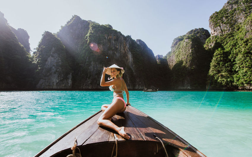 Woman wearing bikini in boat on sea