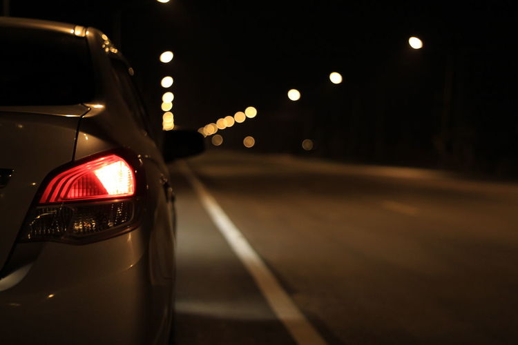 Close-up of illuminated car on road at night