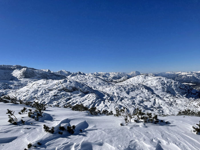 Scenic view of snowcapped mountains against clear blue sky