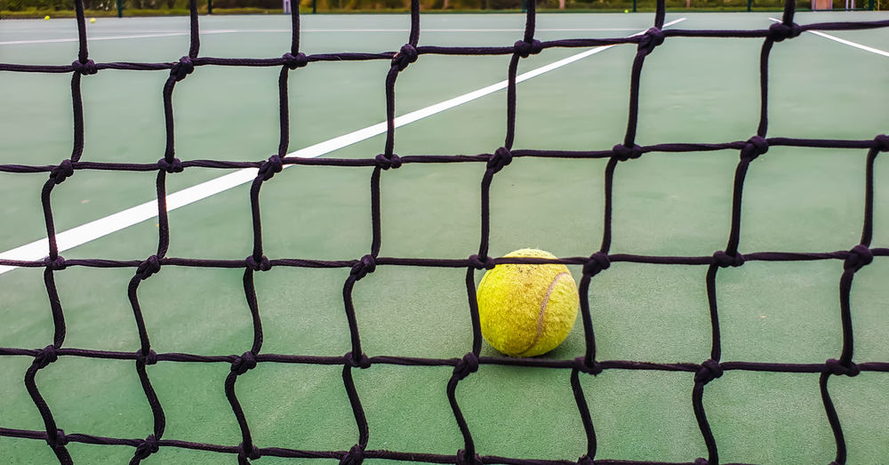 High angle view of yellow ball on chainlink fence