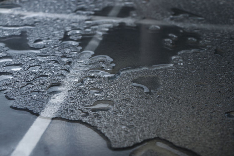 High angle view of raindrops on wet road