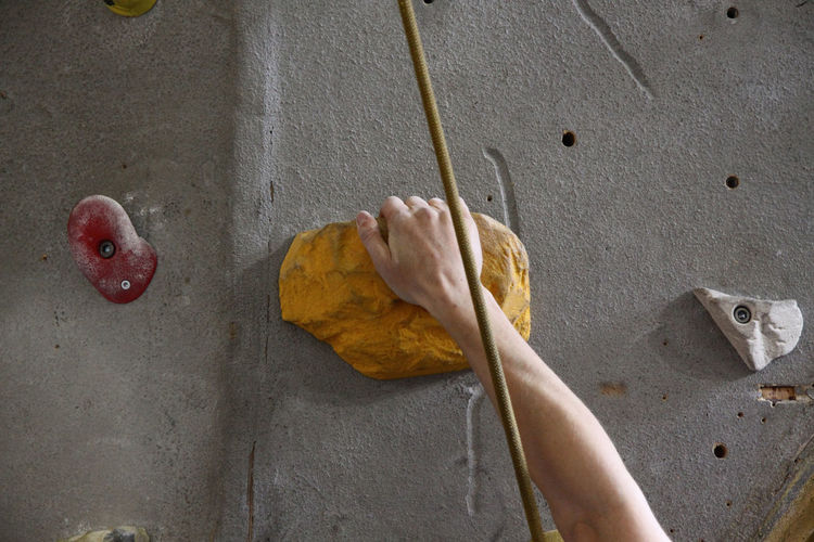 Close-up of hand holding yellow wall