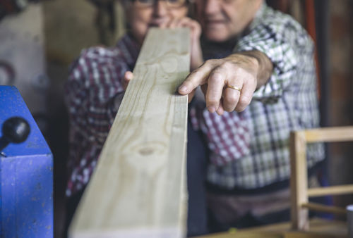 Workers measuring wood in workshop