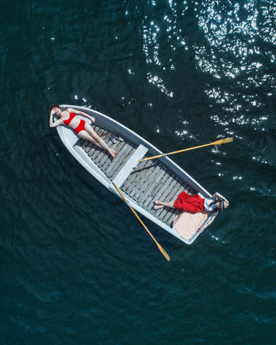 Directly above view of women lying in boat on lake