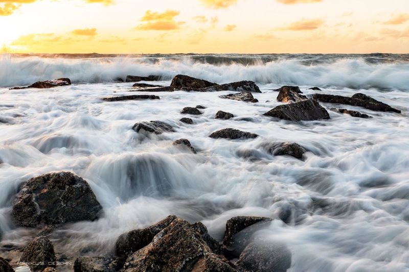 Blurred motion of waves splashing on rocks at shore