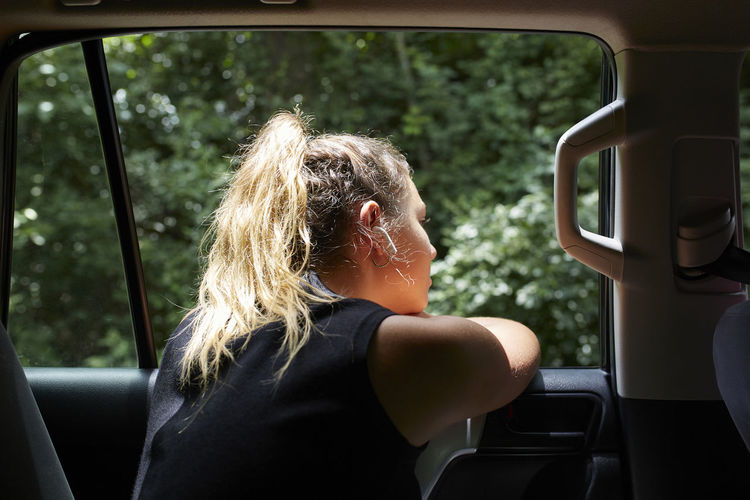 Side view of woman sitting in car