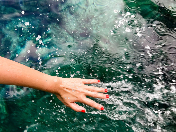 Low section of woman hand in sea