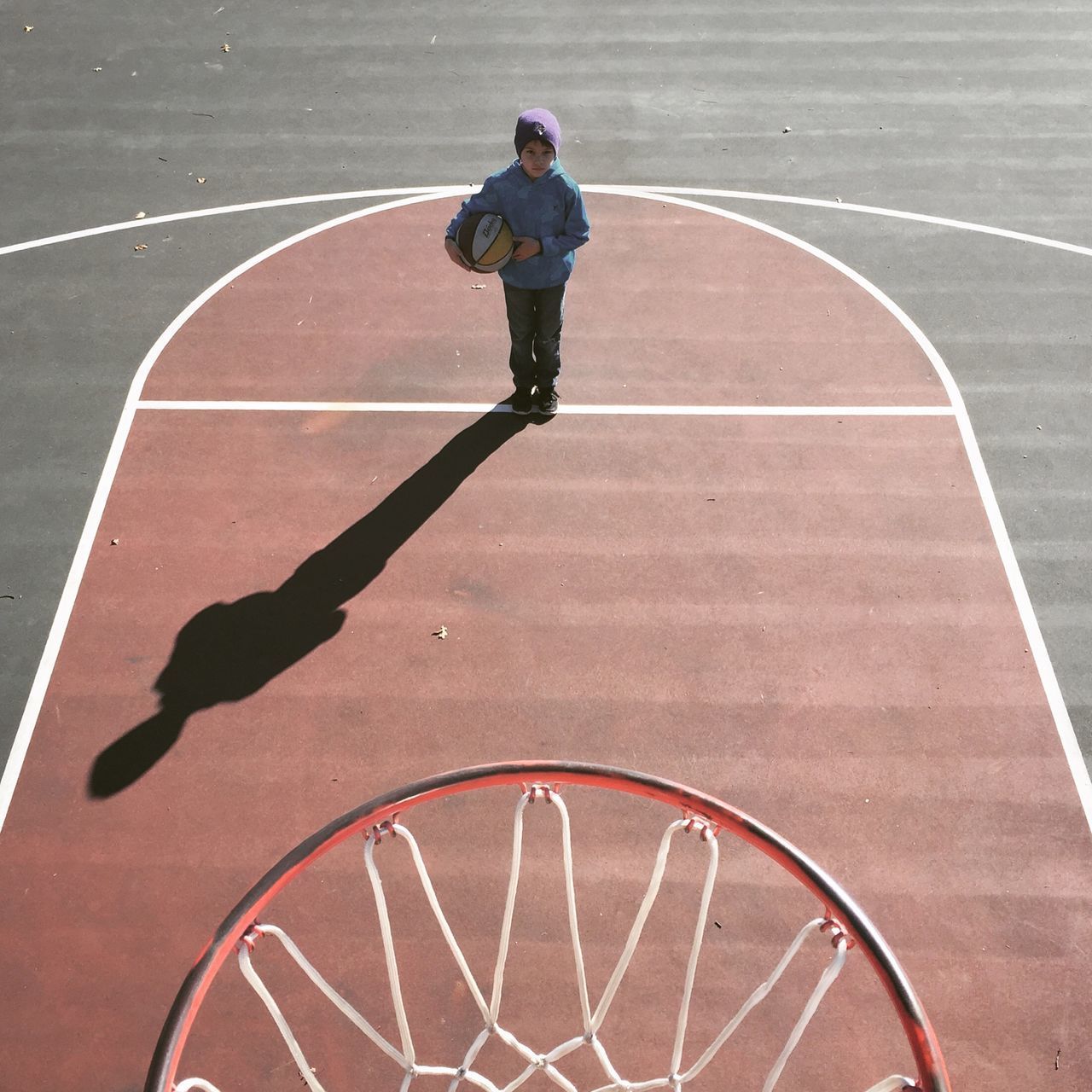 High angle view of boy standing on basketball court