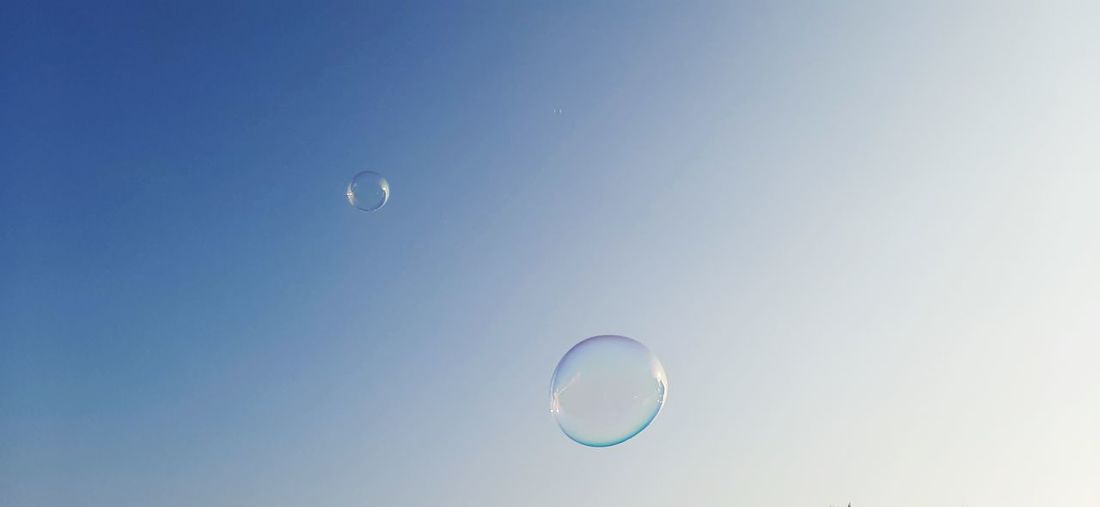 Low angle view of bubbles against moon in sky