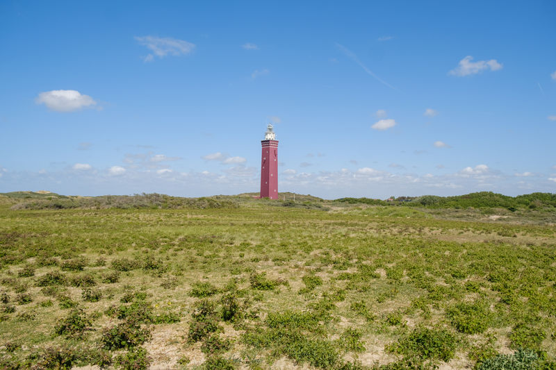 Lighthouse by sea against sky