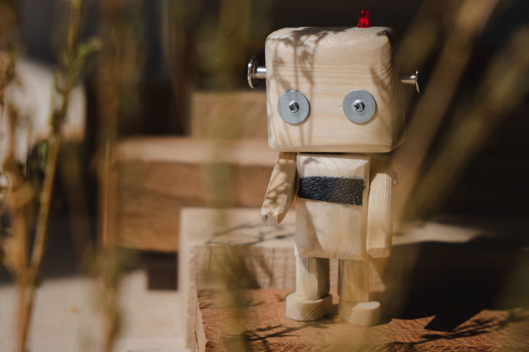 Small wooden robot in the wooden jungle. loneliness concept person