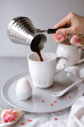 Midsection of person pouring coffee in cup