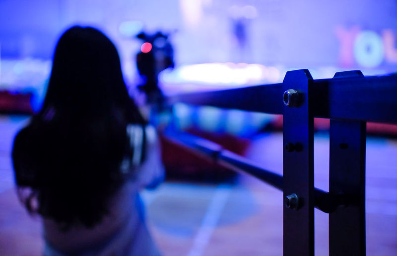 Rear view of woman standing by railing