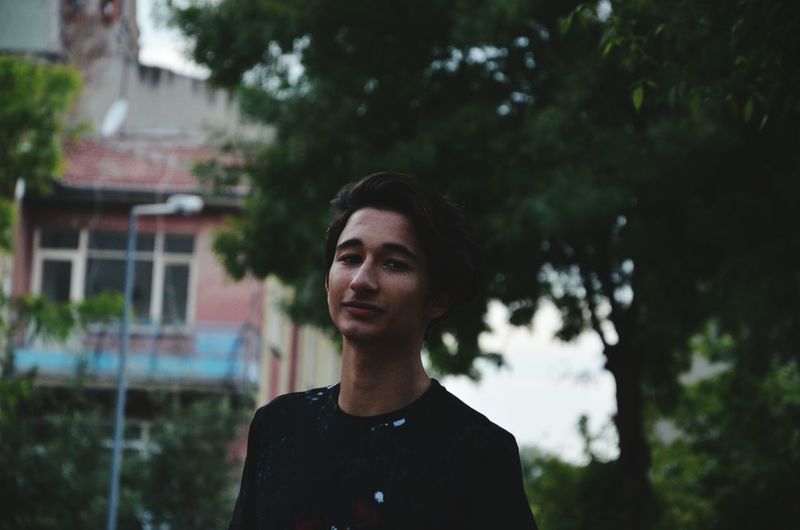 Portrait of smiling teenage boy standing outdoors