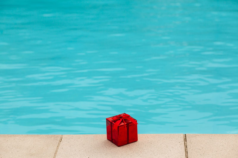 High angle view of red christmas present at poolside