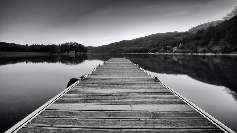 Surface level of wooden jetty leading to calm lake