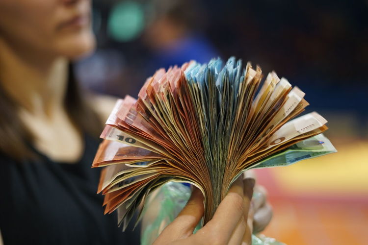 Midsection of woman holding paper currency