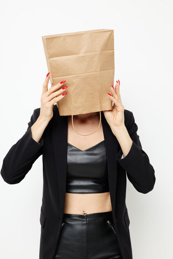 Midsection of woman holding box against white background