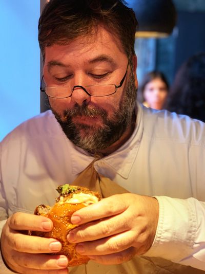 Close-up of man eating burger in restaurant